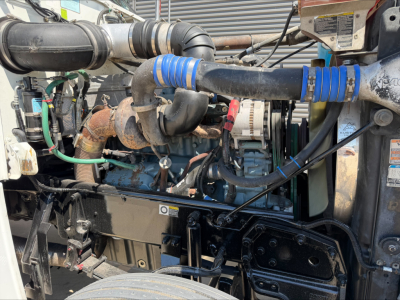 Peterbilt engine bay showing diesel engine with turbocharger, hoses, and belts in service condition.