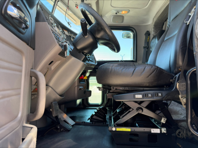 Peterbilt 389 truck cab interior with steering wheel, driver's seat, and dash controls visible.