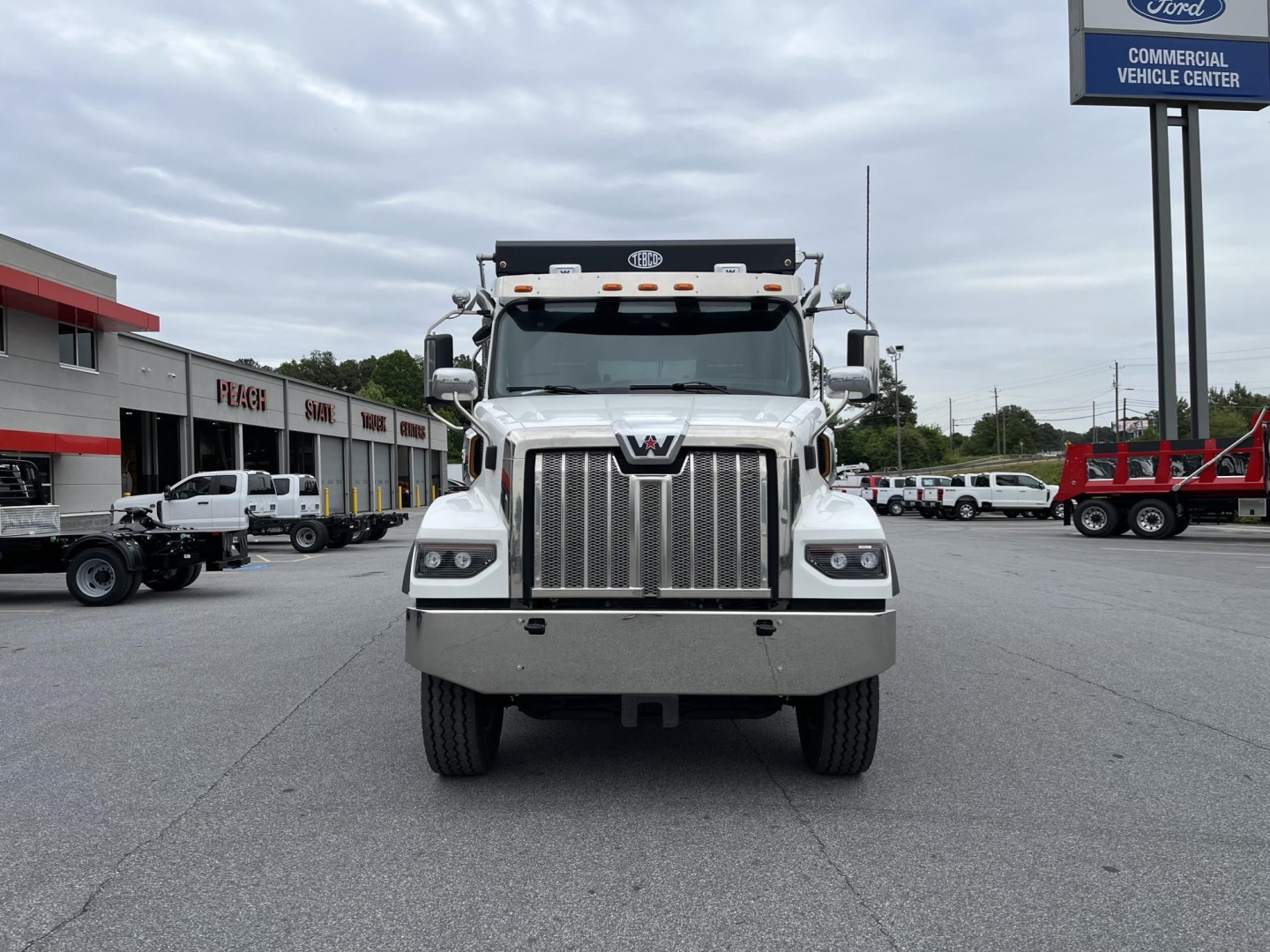 Front view of a white Western Star 47X dump truck showing bold grille and headlights.