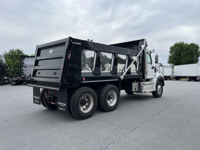 Western Star dump truck with black dump body and dual rear axles, side view showing cargo bed and wheels.