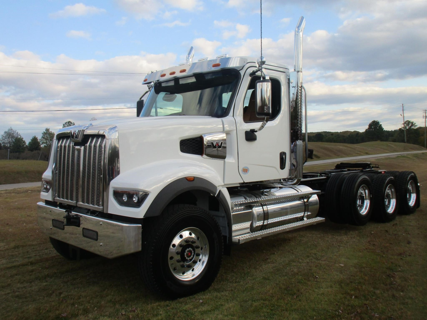Western Star 49X day cab truck in white, front three-quarter view showing chrome grille, wheel, and exhaust stacks.