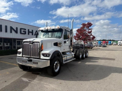 Western Star 49X truck front-left view showing chrome grille, dual exhaust stacks, and daytime running lights; cab with white paint and large mirrors.