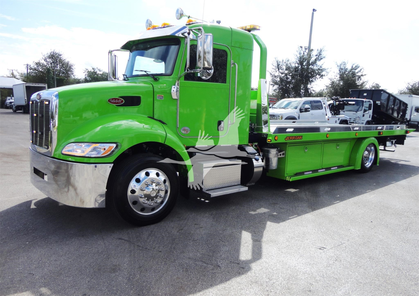 Green 2022 Peterbilt 337 rollback truck with flatbed in-service, side view showing cab chrome bumper and wheels.