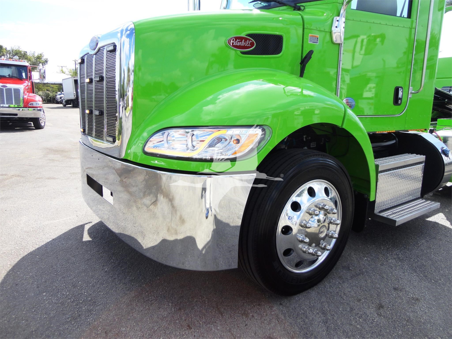 Green Peterbilt 337 truck front fender and chrome bumper with front wheel and headlight visible.