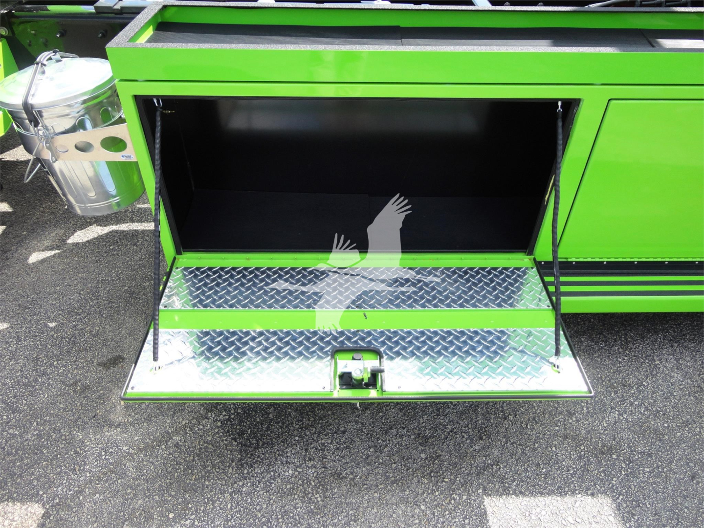 Green Peterbilt 337 rollback truck rear storage compartment open, diamond plate step, stock number J47210, chrome fuel/air canister visible on left.