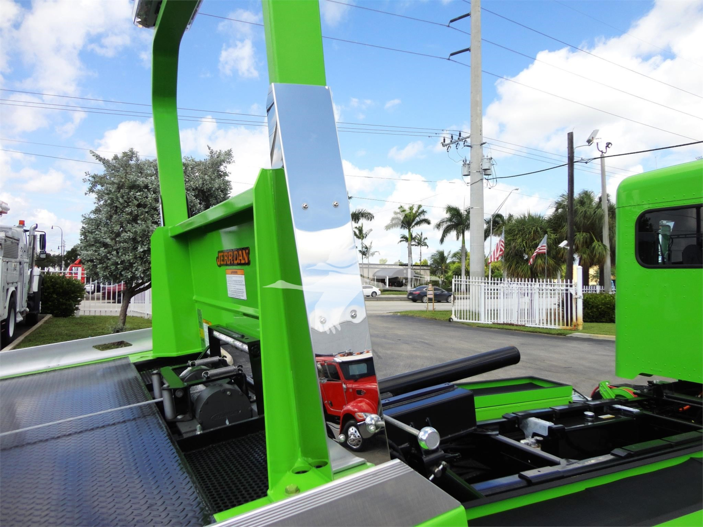 Green Peterbilt 337 rollback truck body with loading platform and chrome mirror showing metal frame and hydraulic components.