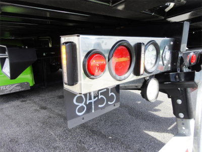 Rear of a 2022 Peterbilt 337 rollback truck showing taillights, license/stock number '8455' on a dark mudflap, metal bumper, and hitch area.