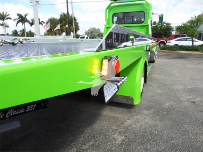 Peterbilt 337 rollback truck rear corner showing bright green paint, taillights, and chrome steps.