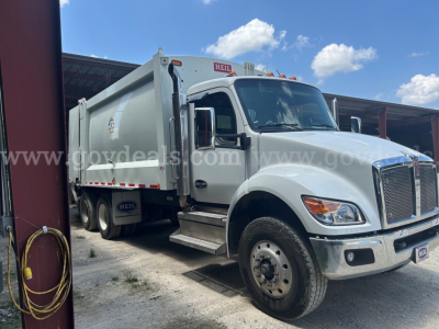 Kenworth T480 dump truck side/front view showing cargo bed, silver exterior, large grille, dual rear wheels, and side steps.