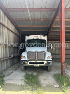 Kenworth T480 truck front view in a metal shelter with grille, headlights, and license plate area visible.