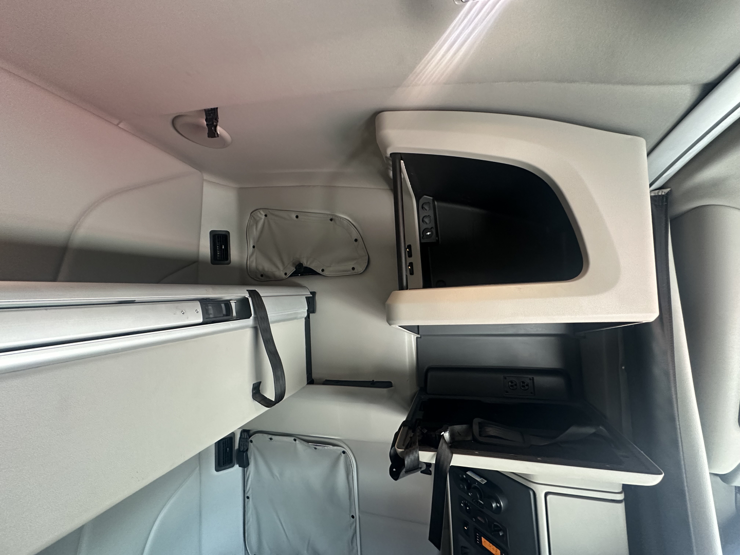 Peterbilt 579 truck cab interior showing storage compartments and dashboard panel with text labels.