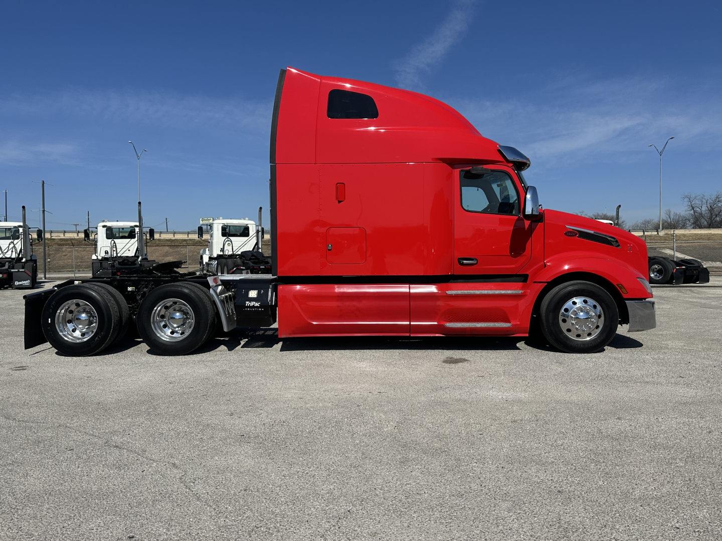 Peterbilt 579 tractor in red side view showing cab and rear axles.