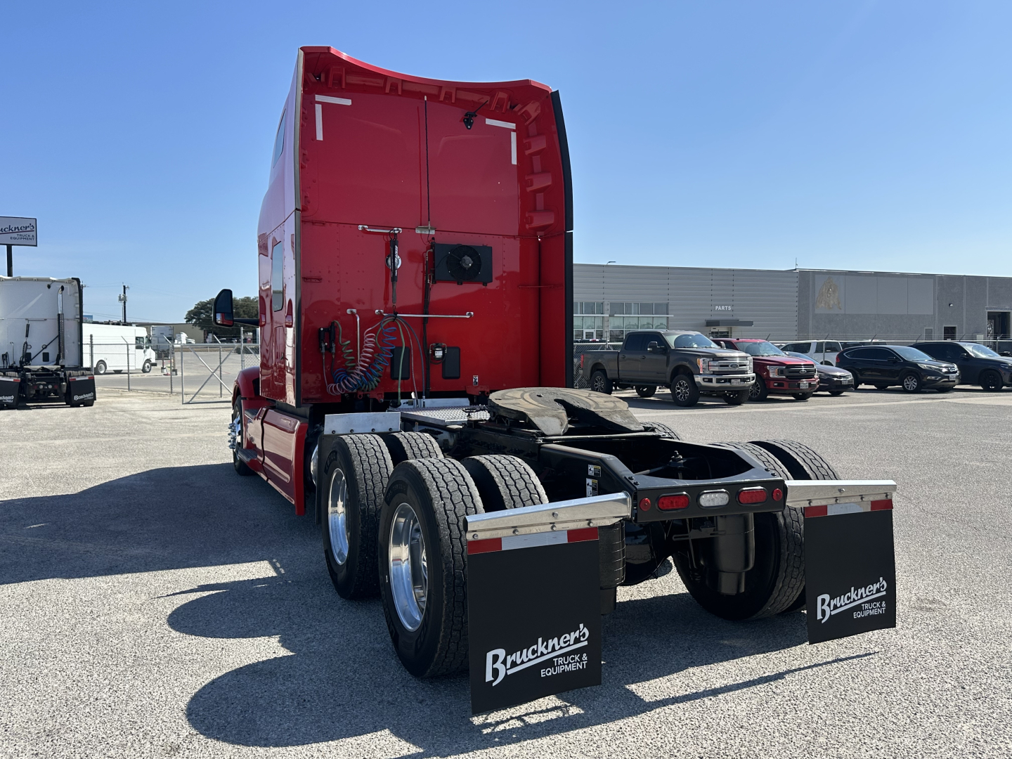 Peterbilt 579 tractor rear view showing dual rear axles and Buckner's truck logo mud flaps.