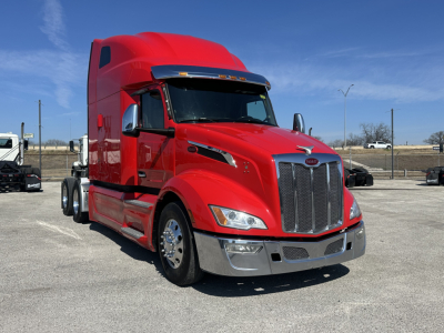 Peterbilt 579 truck in red, front-angled view showing tall sleeper cab, chrome grille, headlights, and bumper.