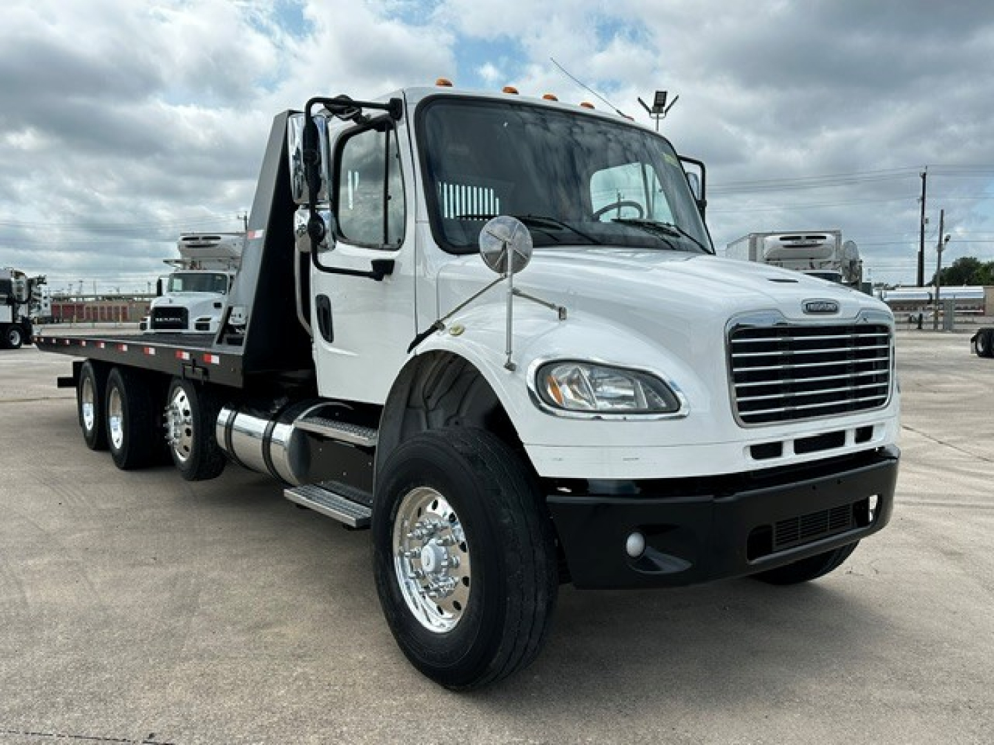 Truck image: 2018 Freightliner M2106 rollback with white cab, flatbed, dual rear axles, chrome wheels, side mirrors, and front grille. Includes VIN and stock not visible in image.