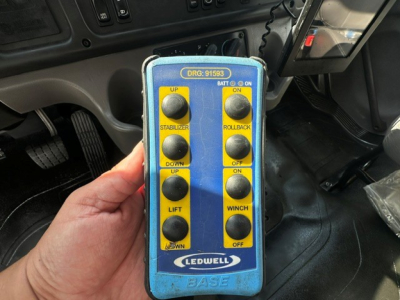 Control pendant with blue housing showing DRG:91593 label and yellow buttons labeled UP STABILIZER, DOWN UP, LIFT, BATT ON, ROLLBACK ON, WINCH OFF, LEDWELL BASE.