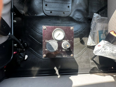 Dashboard panel with gauge and control labeled with PUSH, INCREASE, DECREASE, and other markings; surrounding metal surface and wiring visible.