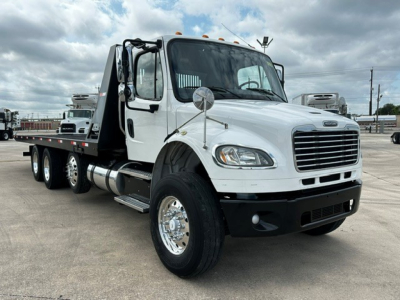 Truck image: 2018 Freightliner M2106 rollback with white cab, flatbed, dual rear axles, chrome wheels, side mirrors, and front grille. Includes VIN and stock not visible in image.