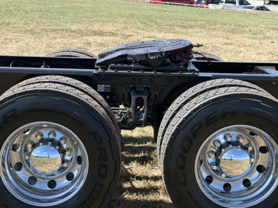 Kenworth T680 truck frame and tandem wheels with dual rear tires and chrome hubcaps.