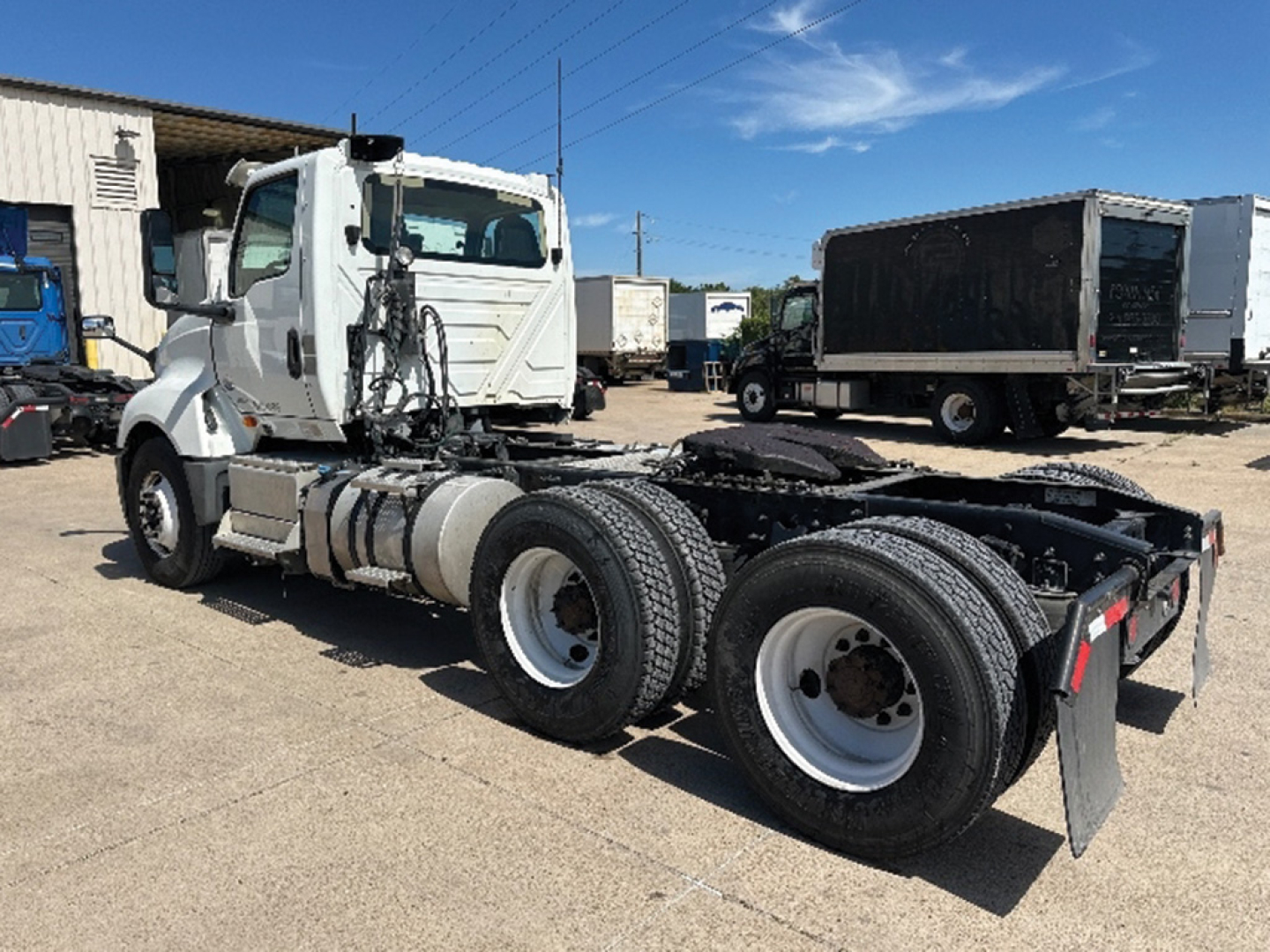 View of a used 2019 International LT625 truck tractor chassis with three-axle configuration, white cab, and fifth-wheel area visible; VIN plate and stock number not shown.