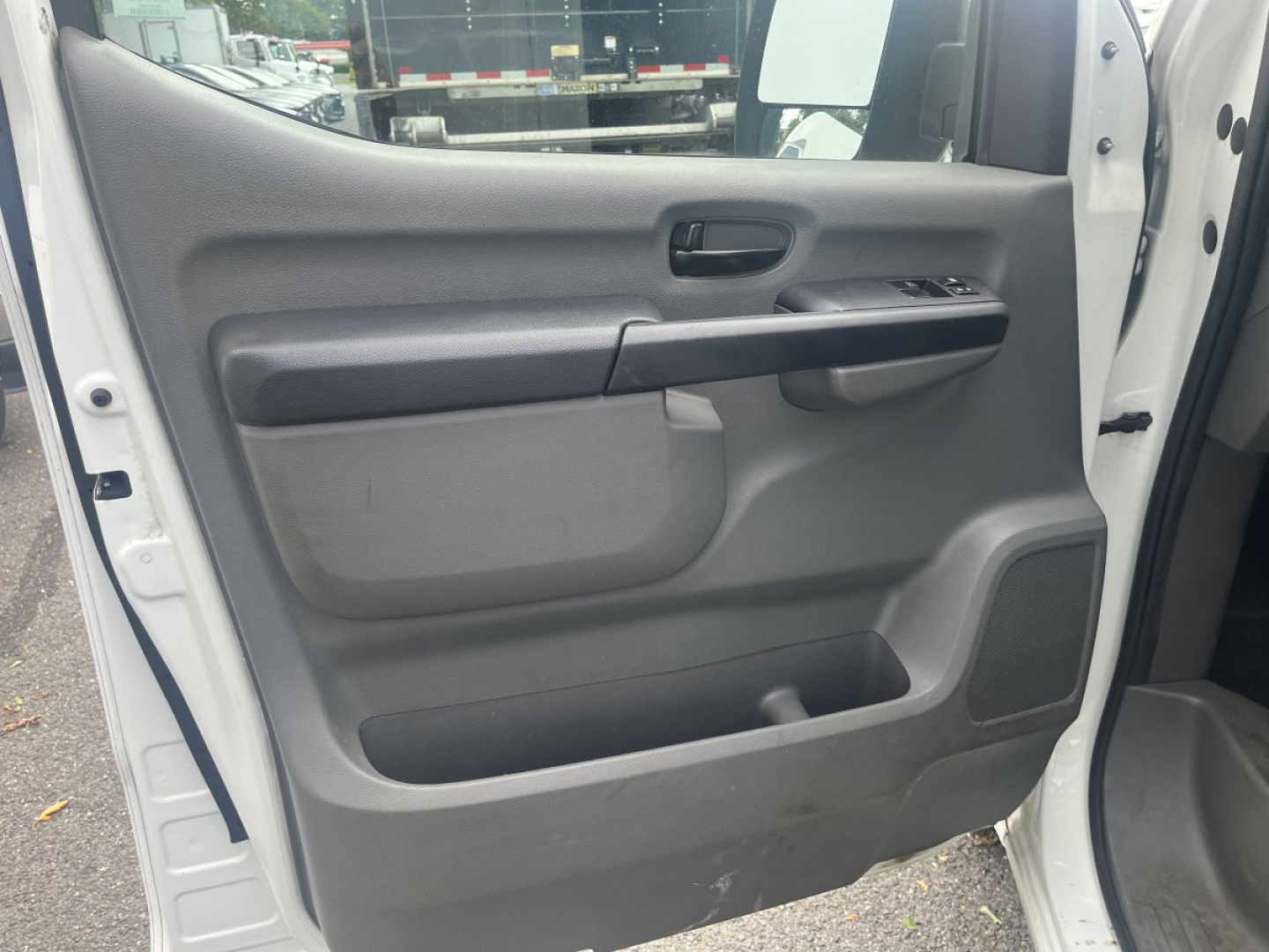 Interior view of a 2019 Nissan NV Cargo door panel showing power window controls, door handle, and storage pocket.
