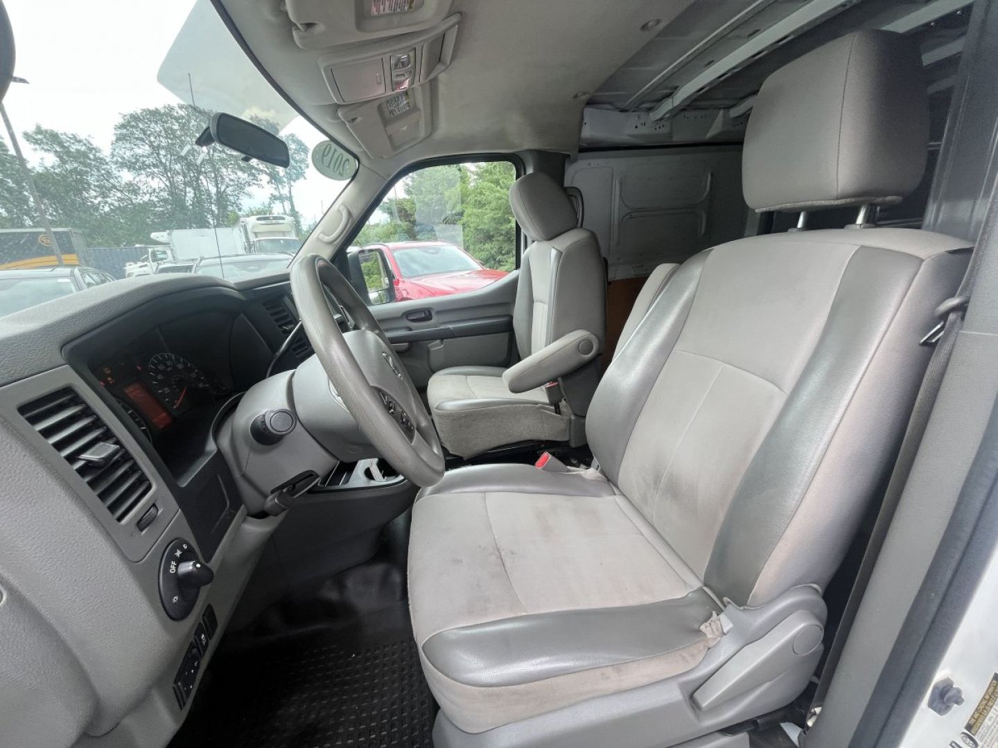 Nissan NV Cargo cab chassis interior showing driver and passenger seats with steering wheel and dashboard