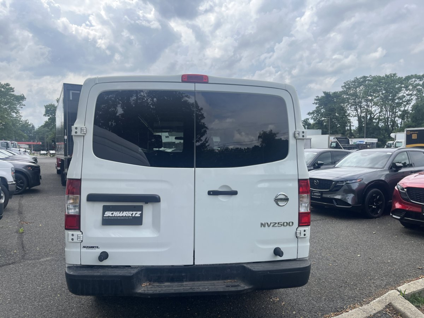 Rear view of a white 2019 Nissan NV2500 cargo van showing dual rear doors, NV3500 badge, and Schm...