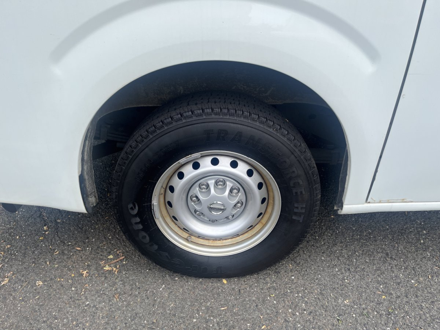 Nissan NV Cargo wheel and tire close-up with steel rim; eye-catching tire brand and tread visible in wheel well.