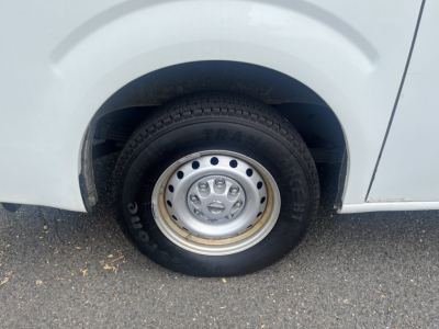 Nissan NV Cargo wheel and tire close-up with steel rim; eye-catching tire brand and tread visible in wheel well.