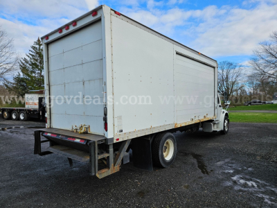 Box truck with a large cargo box on Freightliner M2 chassis, rear underride bar visible, white exterior, license plate not shown, side and rear view.