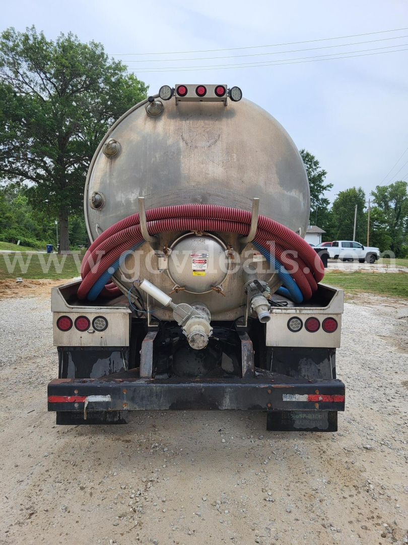 Rear view of a 2019 Freightliner M2 tank truck showing a large circular stainless steel tank with red and blue hoses coiled across the back, multiple valves, and taillights.