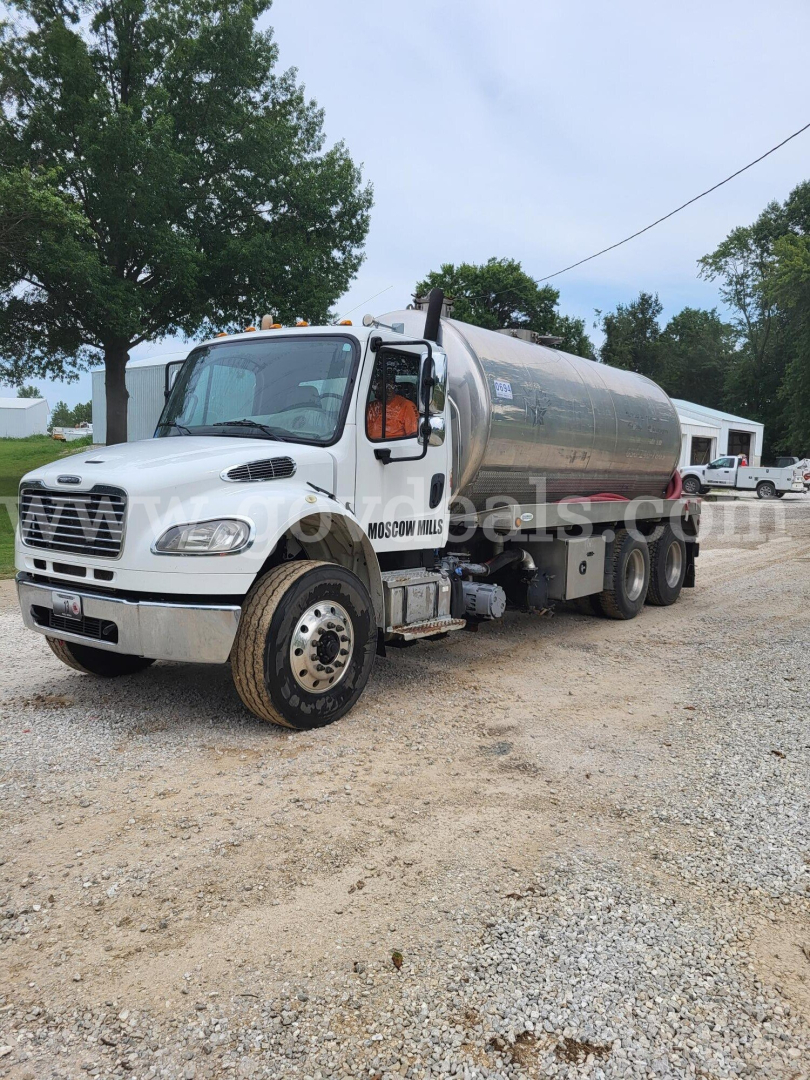 Freightliner M2 tanker truck in a gravel lot, front-left view, chrome fuel tank, white cab, stock number 5111-13 visible.