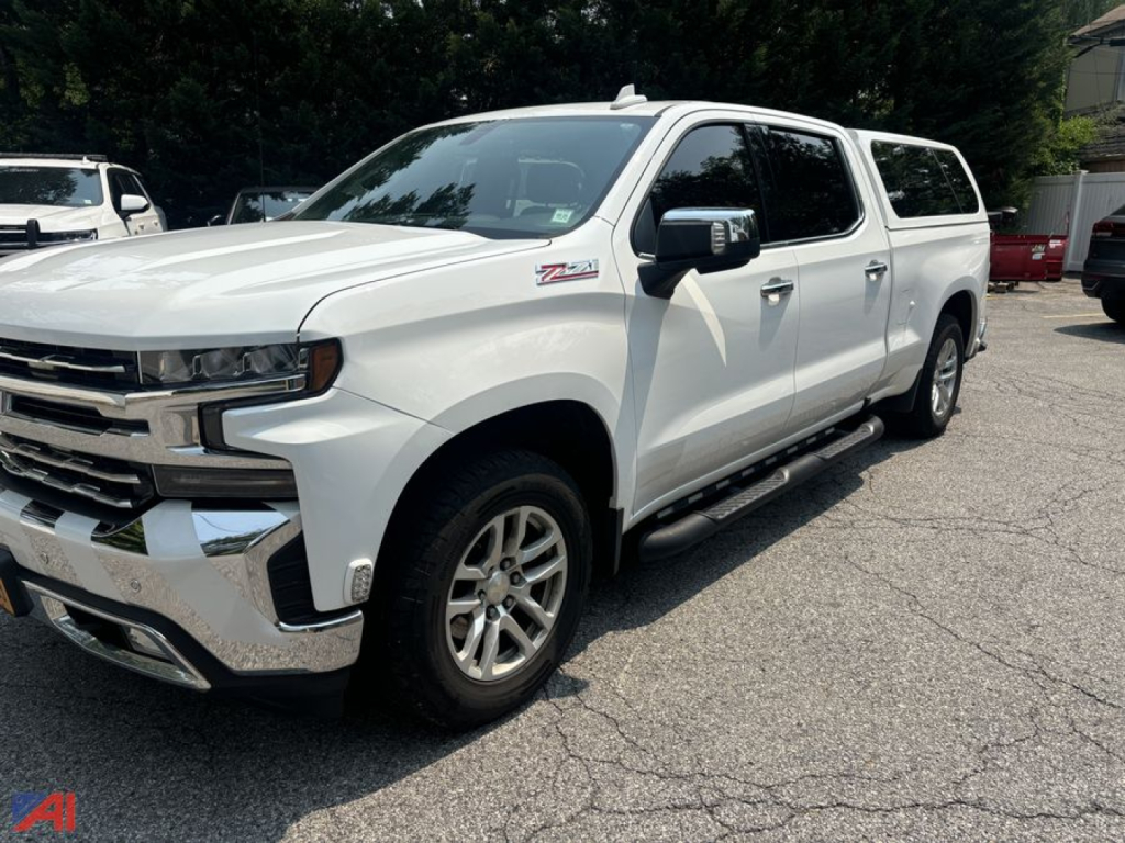 Chevrolet Silverado 1500 Crew Cab pickup with cap, white exterior, side view showing running boards and Z71 badge.