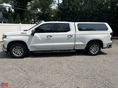 Chevrolet Silverado 1500 Crew Cab pickup with cap, side profile view in light conditions.