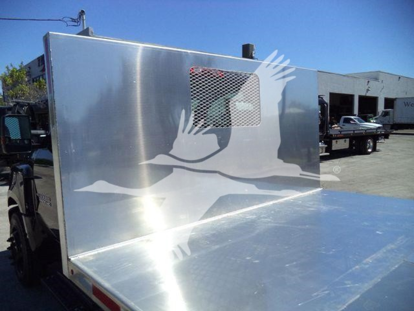 Flatbed area of a 2023 Chevrolet Silverado 6500HD truck with aluminum flatbed and side protection panel.