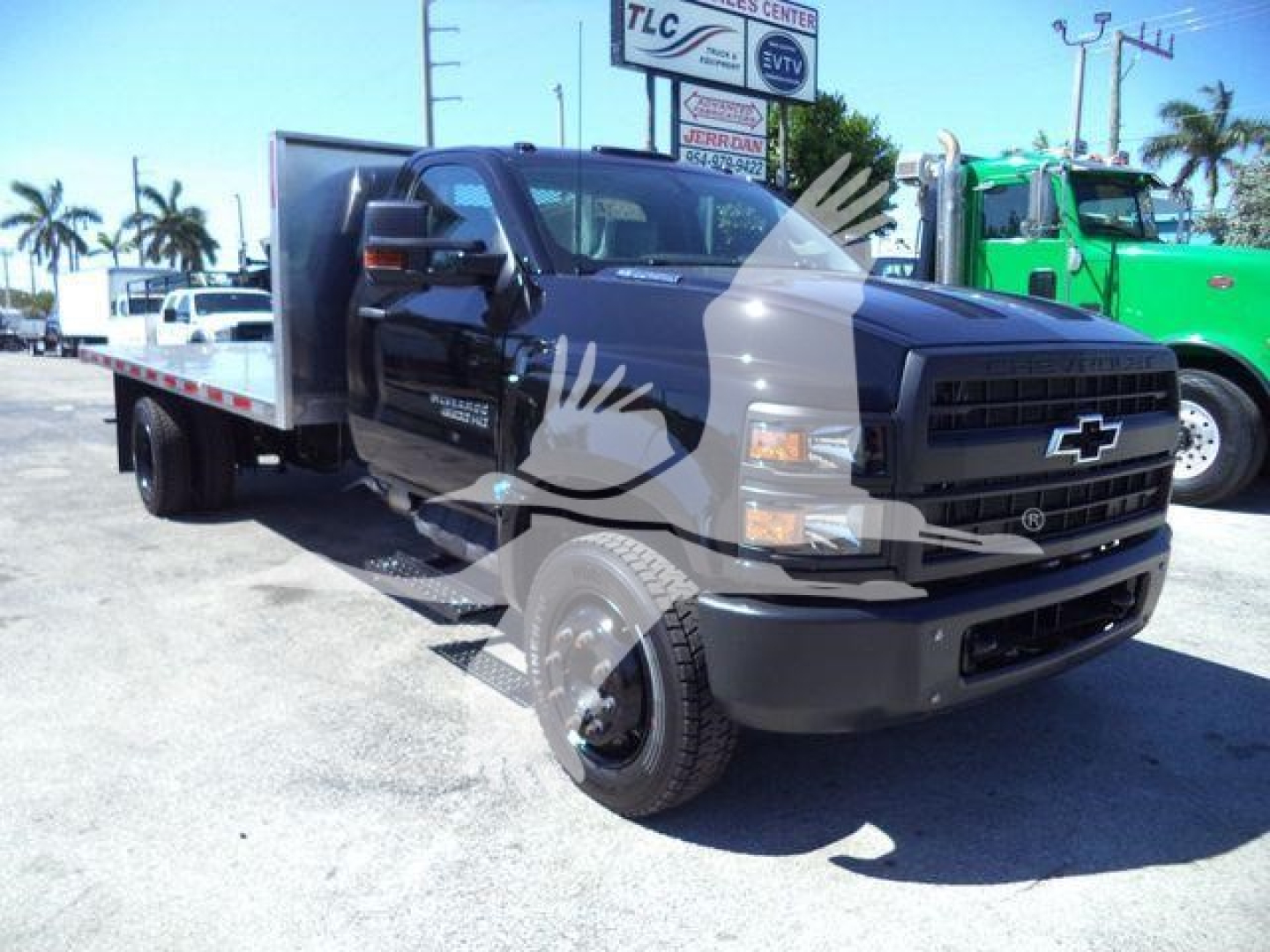 Chevrolet Silverado 6500HD flatbed truck in black front three-quarter view showing flatbed equipment and dual rear wheels.