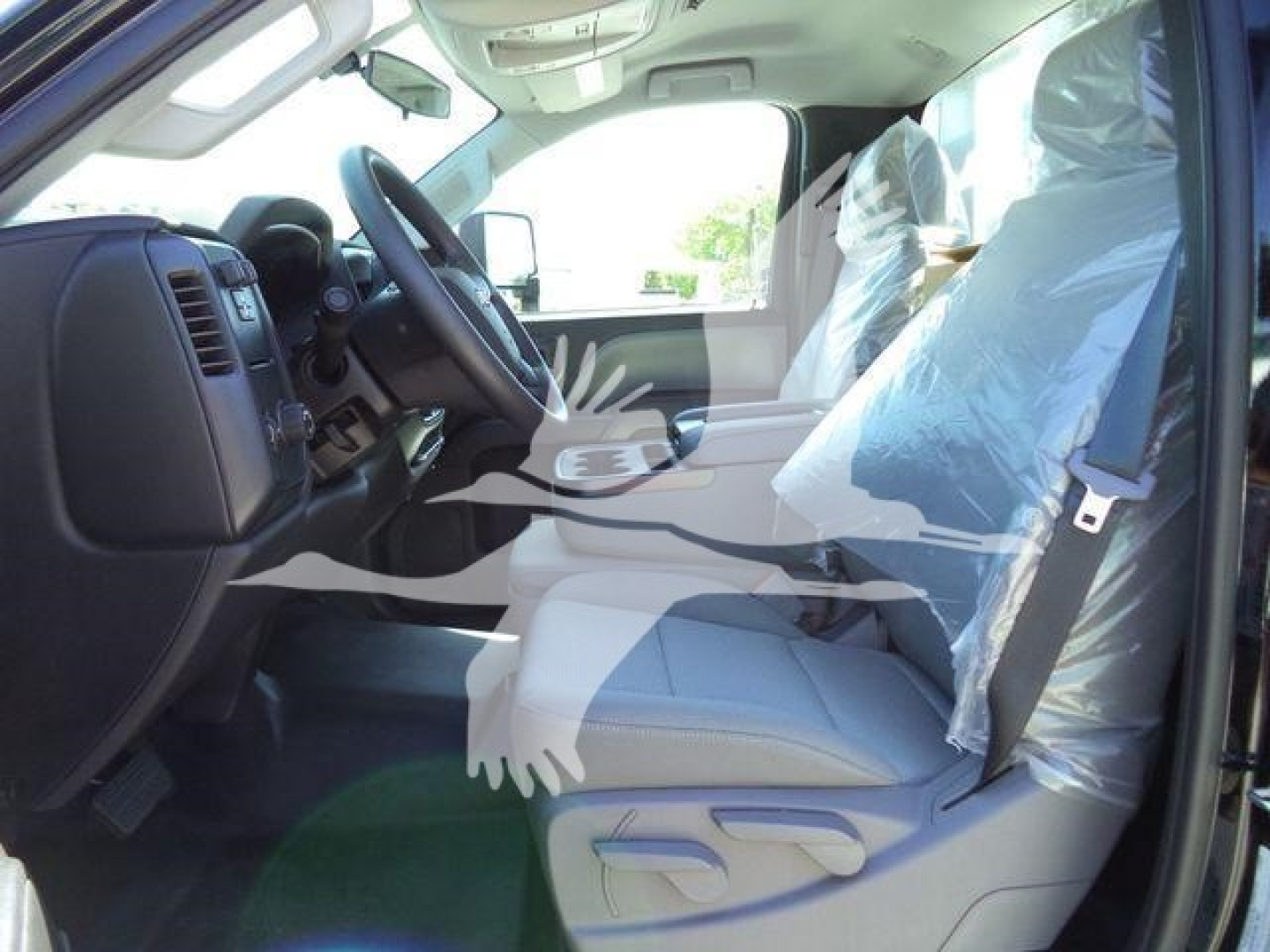 Truck interior showing front seats and dashboard; plastic seat covers on driver and passenger seats; steering wheel visible