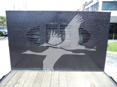 Flatbed truck bed with diamond plate sides and a large cutout graphic of a bird in flight on the side panel.