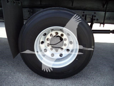Flatbed truck wheel/tyre showing steel rim and fitted hub; side view of rear axle with black tire and white rim