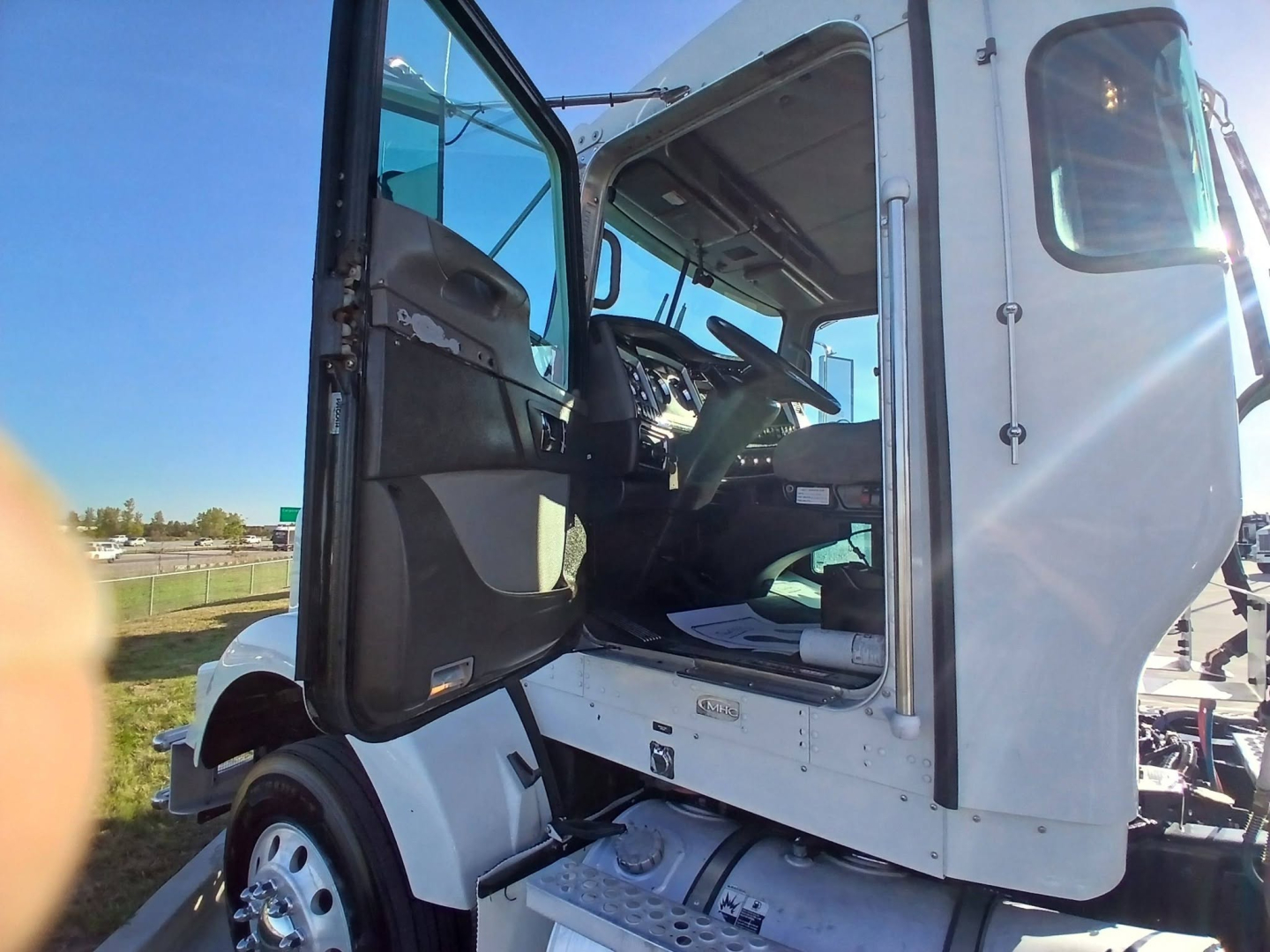 Kenworth T800 truck cab interior view of the driver seat, door open, from outside the vehicle.
