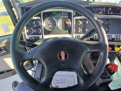 Kenworth T800 dash and steering wheel in-cab view showing gauge cluster and steering wheel with Kenworth emblem.