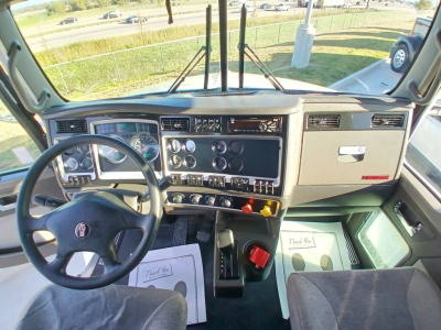 Kenworth T800 cab interior/dashboard view from driver seat with steering wheel, gauges, switches, and center console.