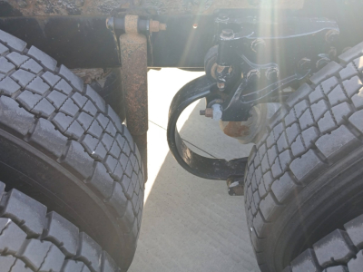 Kenworth T800 chassis view showing dual rear axles and suspension components with tires visible.