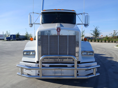 Kenworth T800 conventional sleeper truck front view with large chrome grille and bumper, logo on hood, clear headlights, and dual side mirrors.