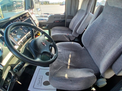 Kenworth T800 cab interior showing steering wheel dashboard and front seats.