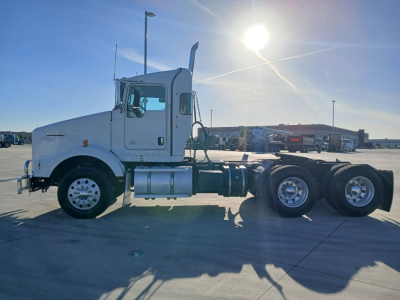 2020 Kenworth T800 tractor side view showing cab, fuel tanks, and dual rear axles. Visible stickers and components include the Kenworth badge on the sleeper, fuel tanks, and wheel rims.