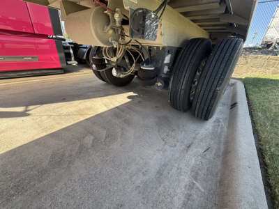Trailer undercarriage showing dual rear axles with tires and suspension components for a Hicks SL3932 dump trailer