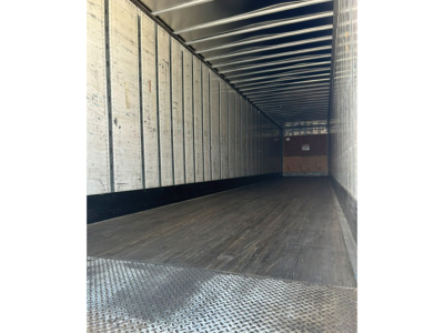 Interior of a 2005 Utility 4000D-X trailer showing empty cargo area with wood floor, metal side walls, and a rust-colored back door at far end.