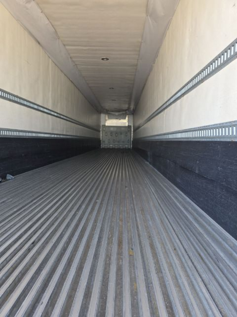 Trailer interior showing ribbed metal floor and side rails of a 2005 Utility 3000R reefer trailer, empty interior with rear ramp.