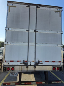 Rear view of a 2005 Utility 3000R trailer with metal doors and latches, license plate visible, and taillights.